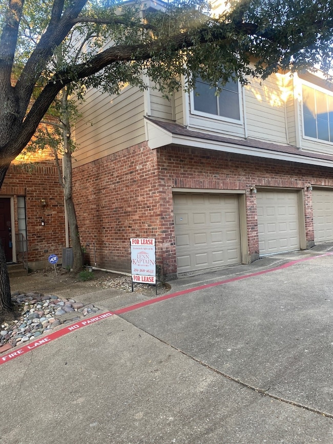 View of property exterior featuring brick siding and an attached garage