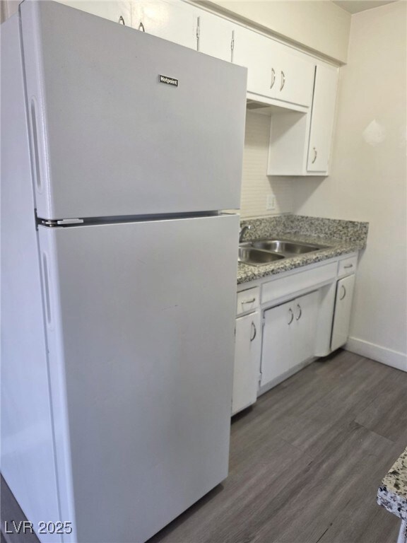 Kitchen featuring freestanding refrigerator, dark