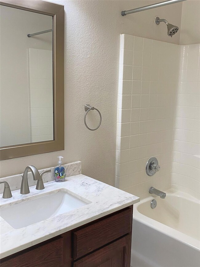Bathroom featuring vanity and  shower combination