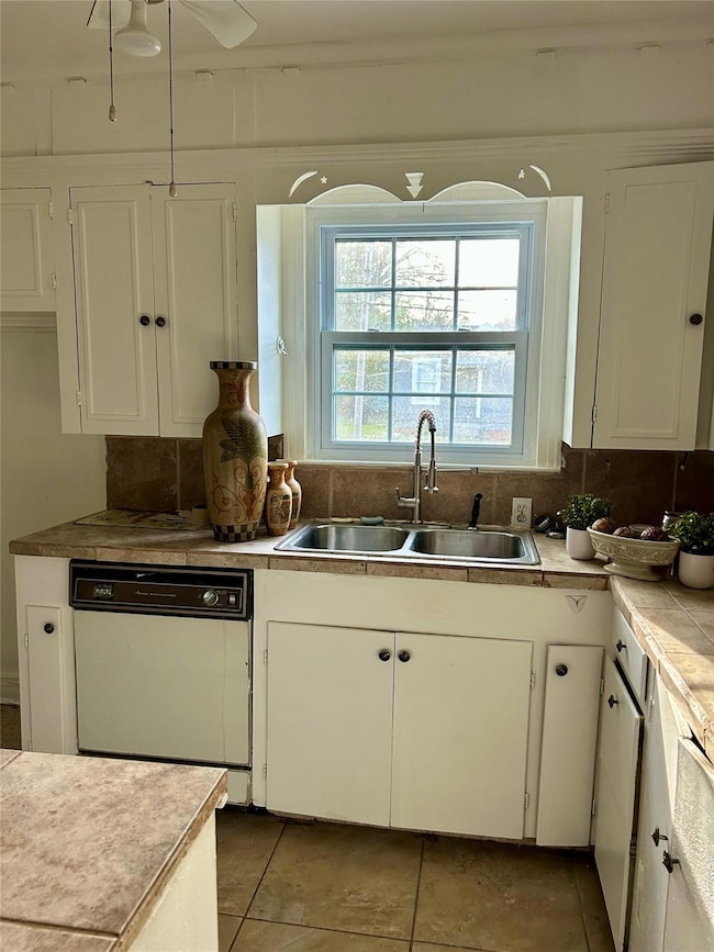 Kitchen featuring a ceiling fan, a sink, white cab