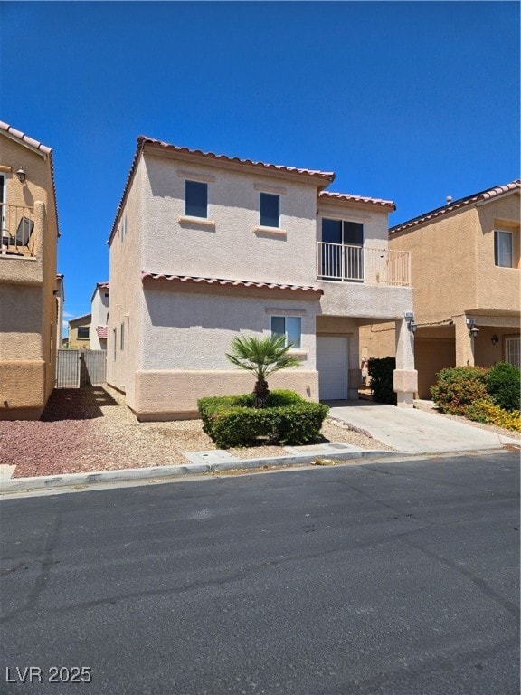View of front facade featuring a balcony, driveway