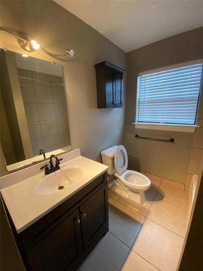 Full bath featuring tile patterned flooring, toile