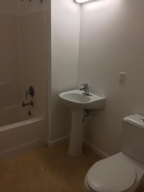 Guest bathroom with shower over tub.