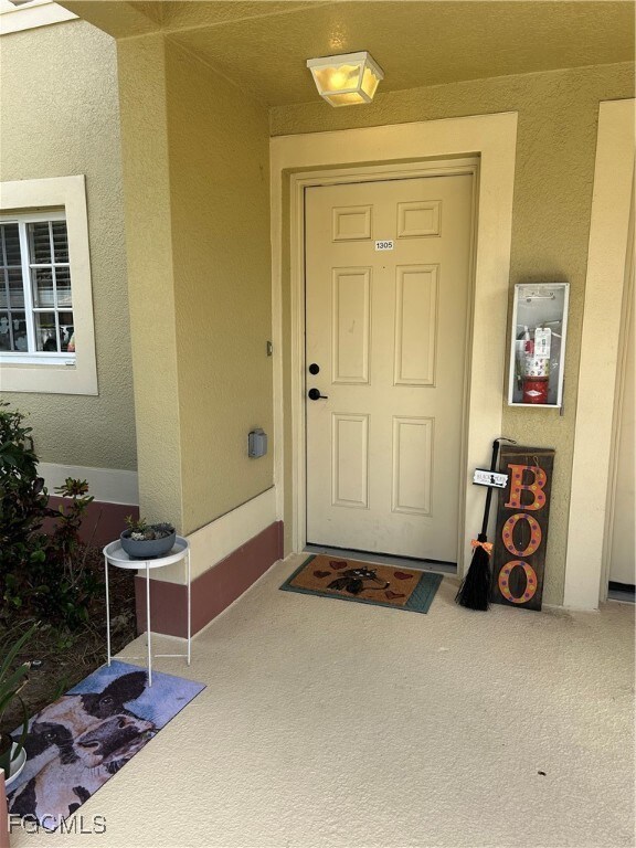 Entrance to property featuring stucco siding.
