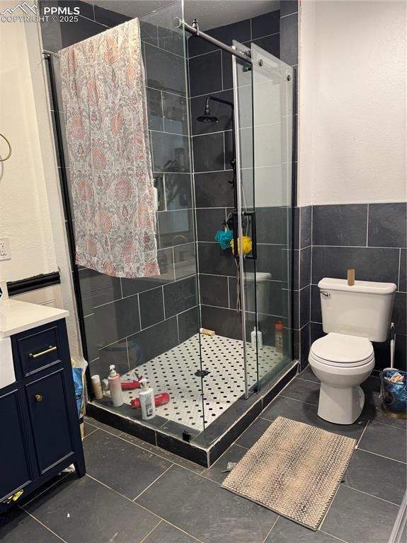 Full bath featuring a shower stall, toilet, tile walls, and tile patterned flooring