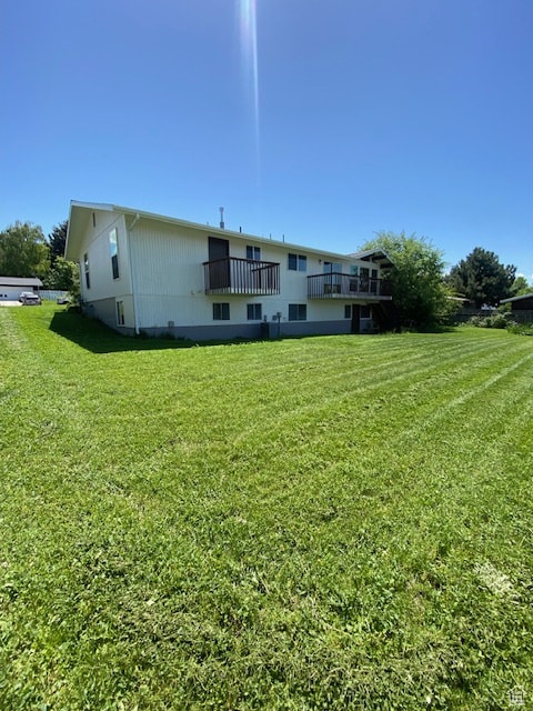 Rear view of house featuring a yard