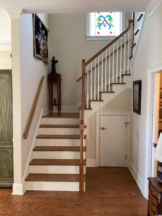 Stairs with baseboards and wood finished floors