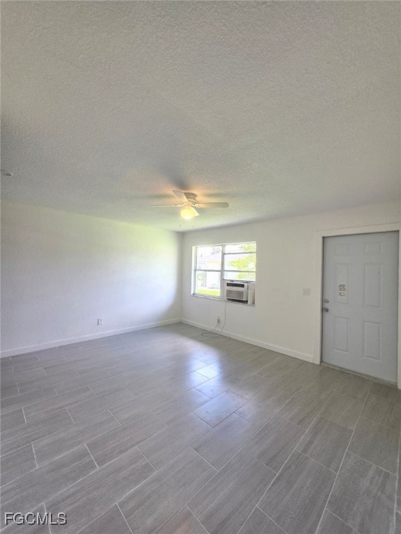 Unfurnished room with ceiling fan, a textured ceil