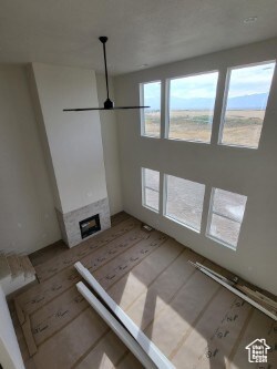 Unfurnished living room featuring a fireplace and a ceiling fan