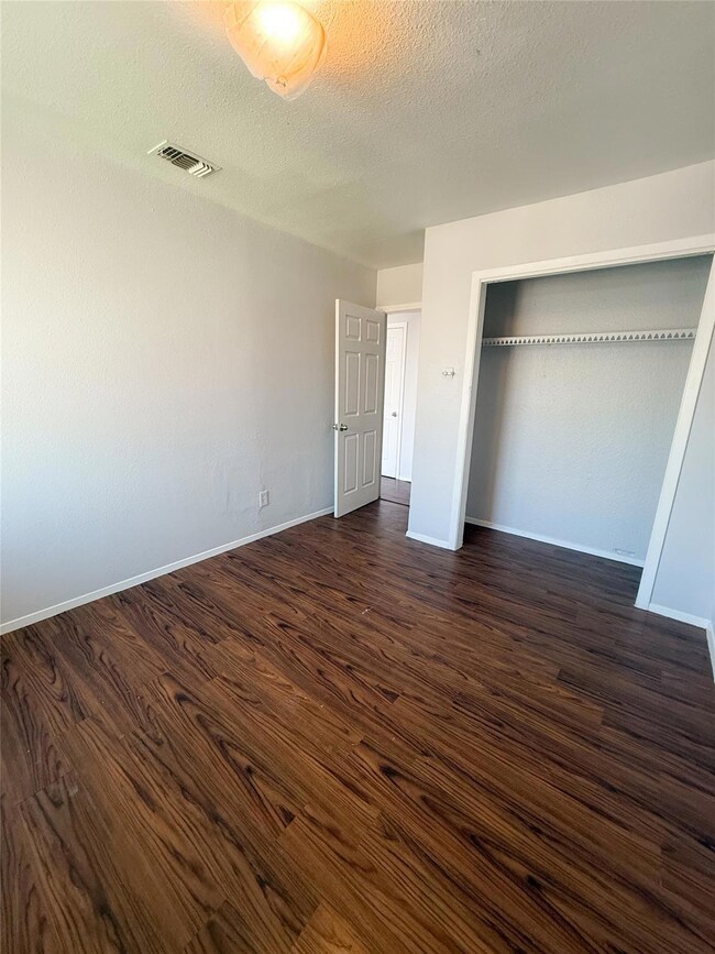 Unfurnished bedroom featuring visible vents, base