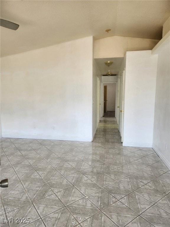Unfurnished room featuring lofted ceiling and base
