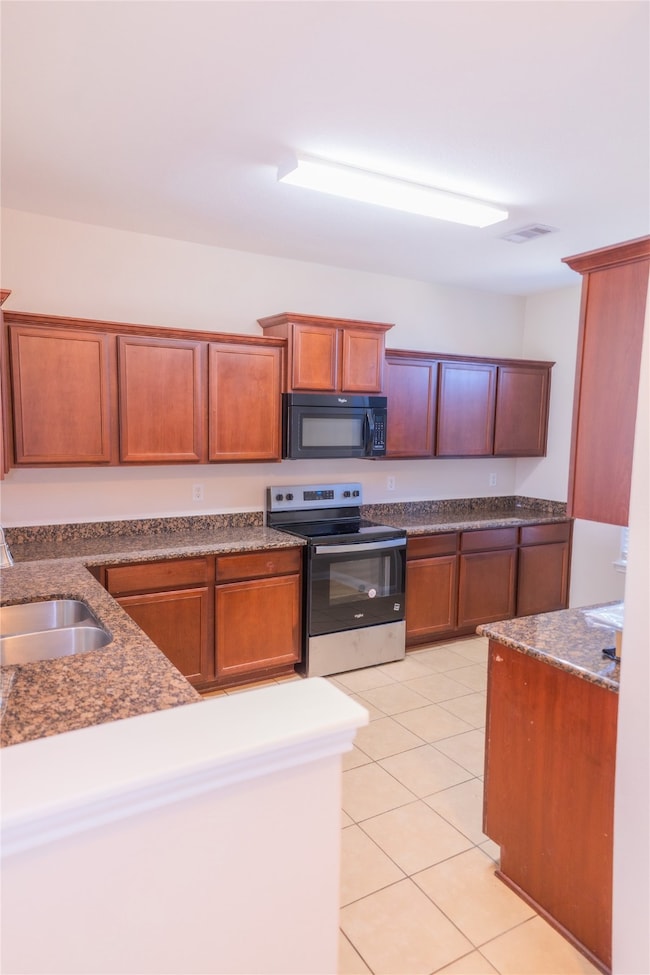 This kitchen features ample wooden cabinetry, gran