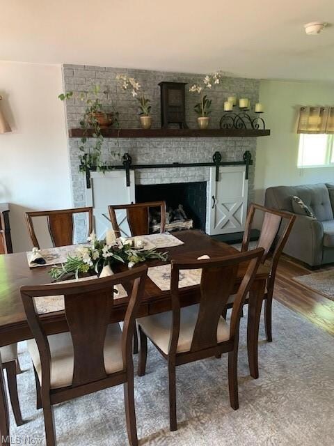 Dining space with a fireplace and wood-type floori