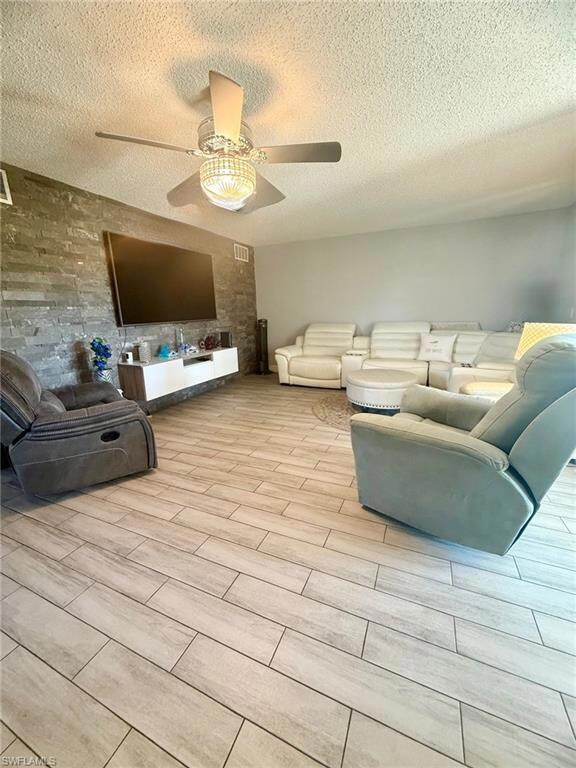 Living area with a textured ceiling, wood finish f