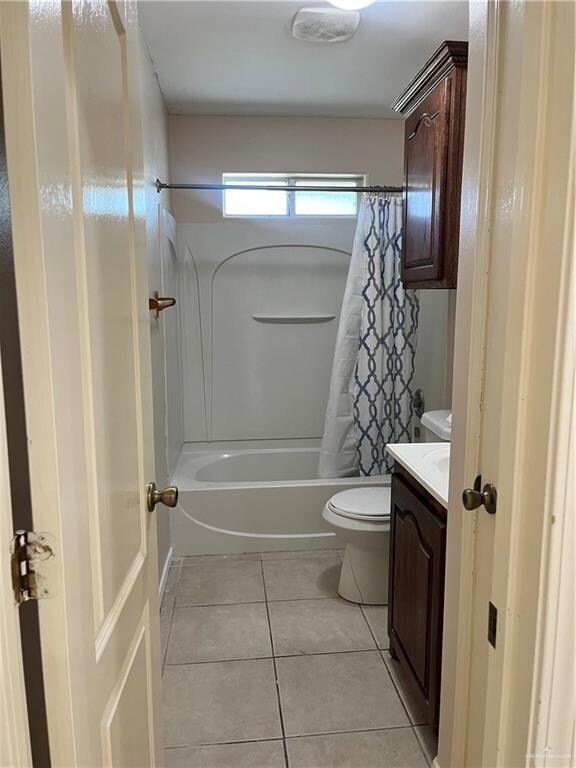Full bathroom featuring vanity, tile flooring, toilet, and shower / bathtub combination with curtain
