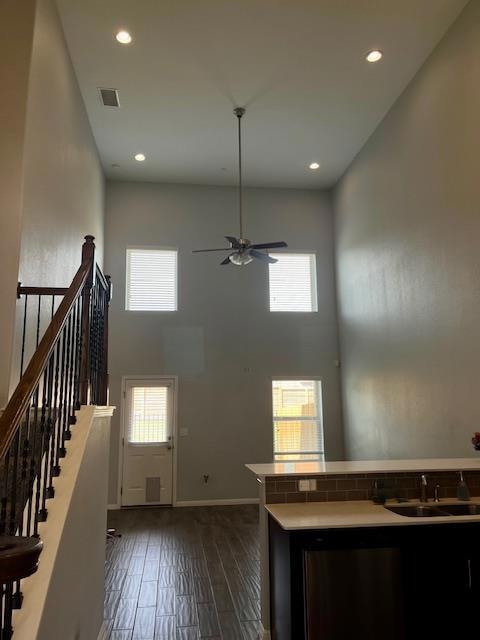 Foyer entrance with a high ceiling, healthy amount of natural light, dark wood-style flooring, ceiling fan, and recessed lighting