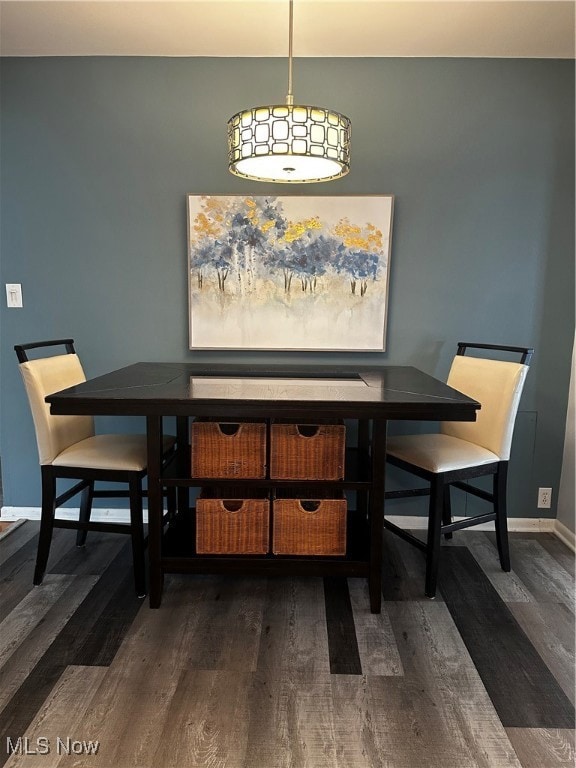 Dining area with dark hardwood / wood-style flooring
