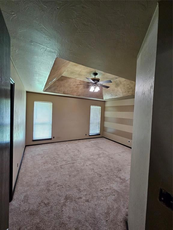 Empty room featuring carpet flooring, ceiling fan, and a textured ceiling