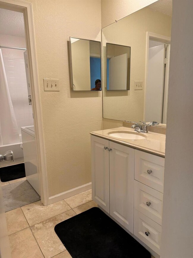 Full bath with vanity, tile patterned floors, a t