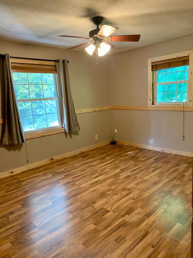 The master bedroom is on the upper level and features a ceiling fan.