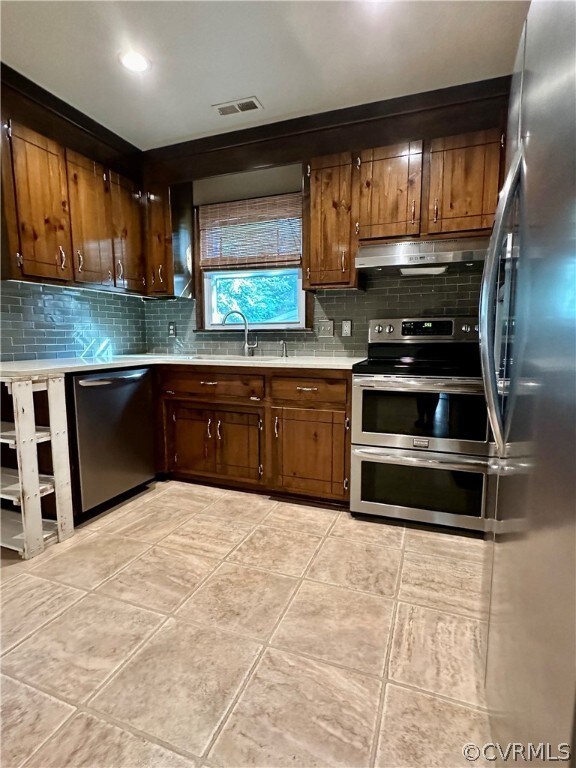 Kitchen with backsplash, appliances with stainless