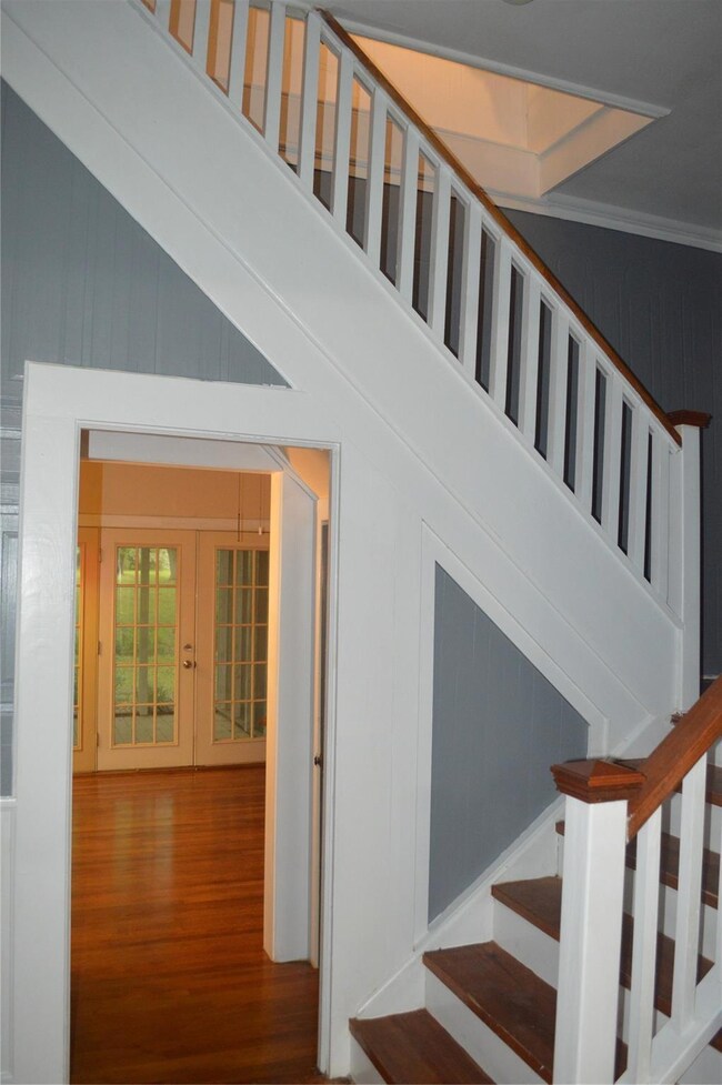 Stairs with french doors, crown molding, and hardw