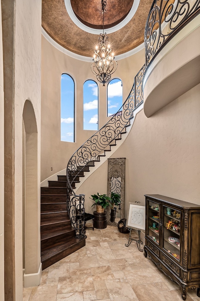 Wrought iron staircase with custom details in dome ceiling. The door to the left is the hall to the private second bedroom down with en-suite bath.