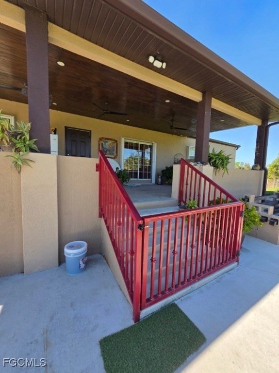 View of patio with stairway and ceiling fan