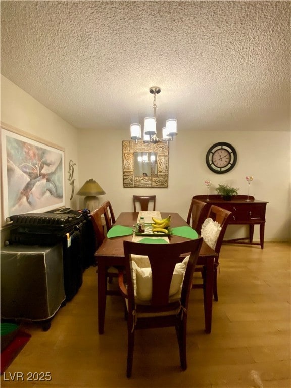 Dining space with a chandelier, a textured ceiling