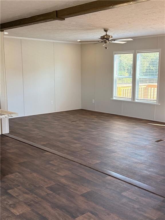Unfurnished room featuring a textured ceiling, dark wood-style floors, beam ceiling, ceiling fan, and a decorative wall