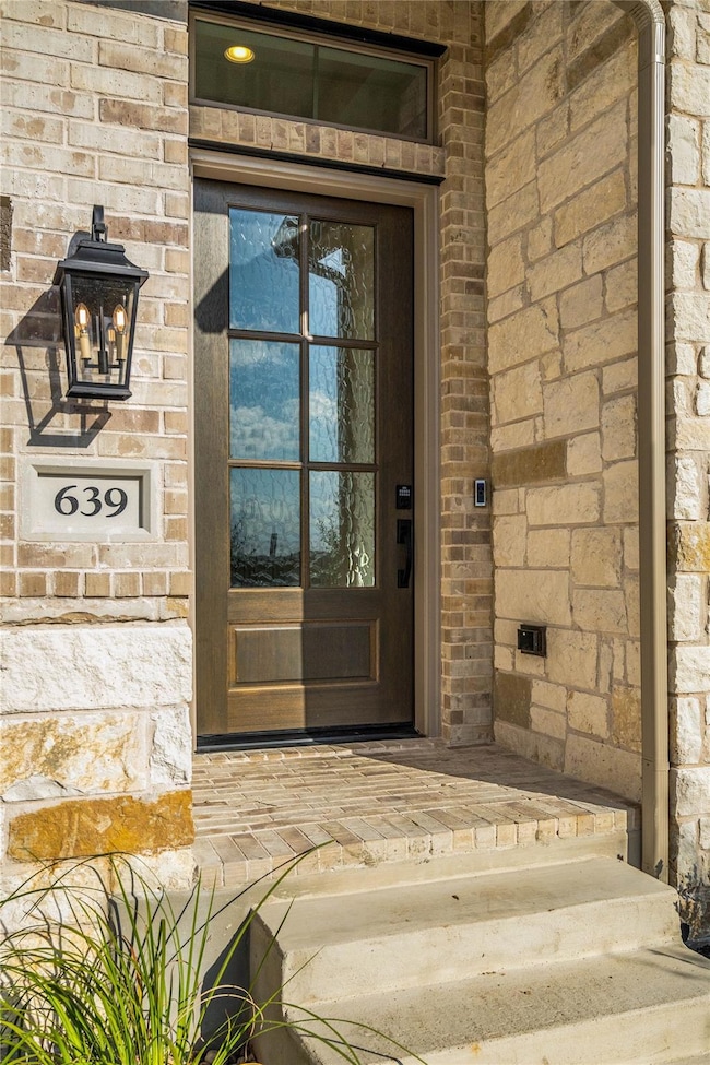 View of exterior entry featuring stone siding and
