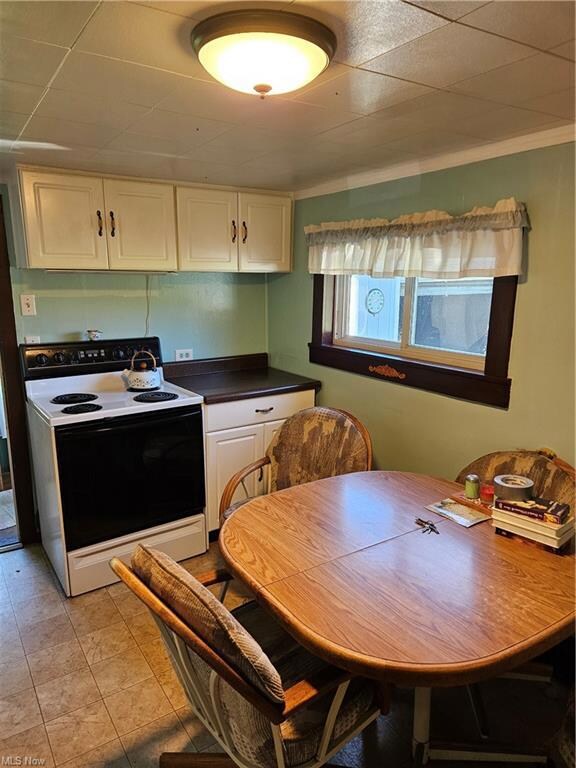 Kitchen with stove, light tile floors, and white c