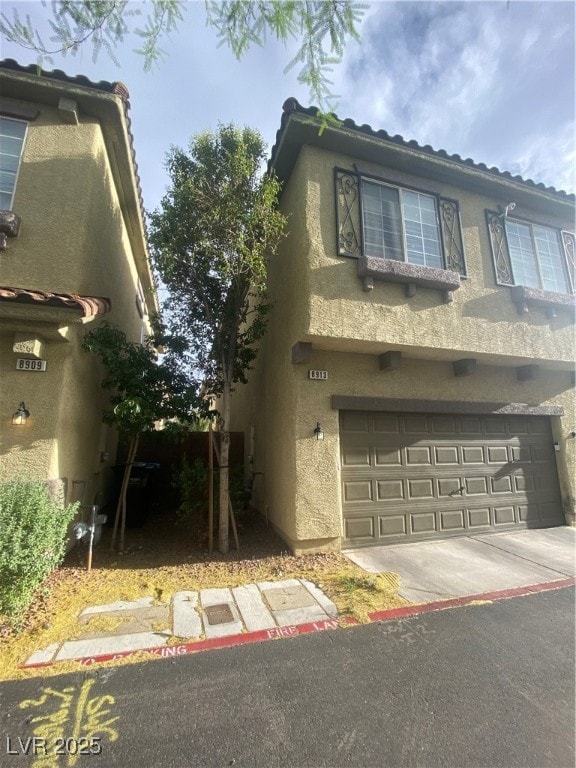 View of front of house with stucco siding, an atta