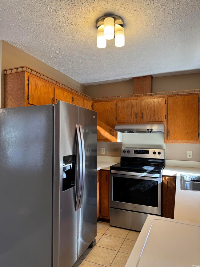 Kitchen featuring exhaust hood, sink, a textured c