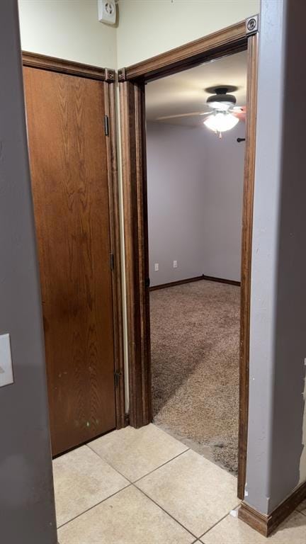 Hallway featuring tile patterned floors and carpet floors
