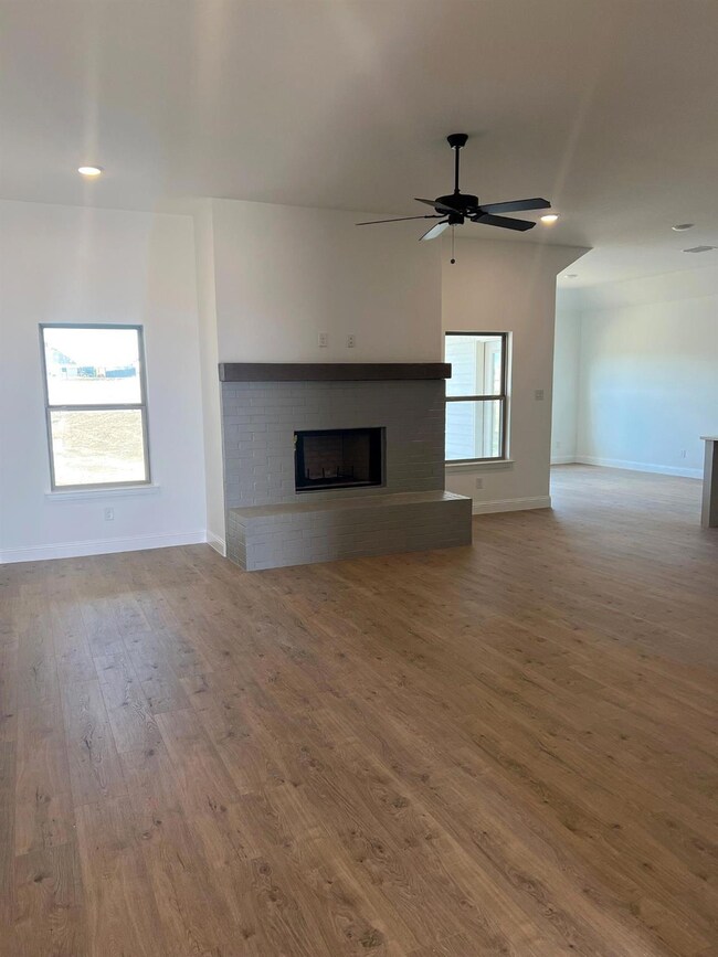 Large living room with painted brick wood burning fireplace