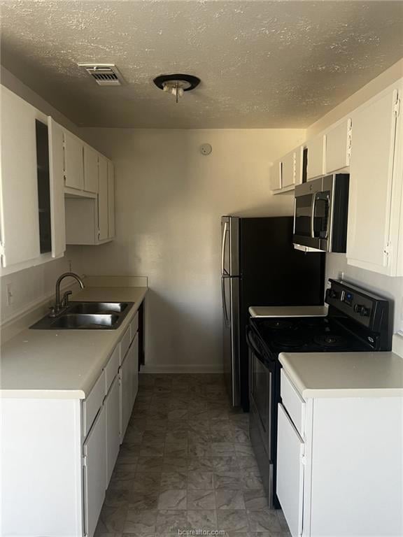 Kitchen with a textured ceiling, white cabinetry, black electric range oven, and sink