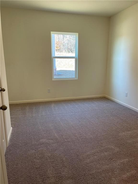 Empty room featuring baseboards and dark colored c
