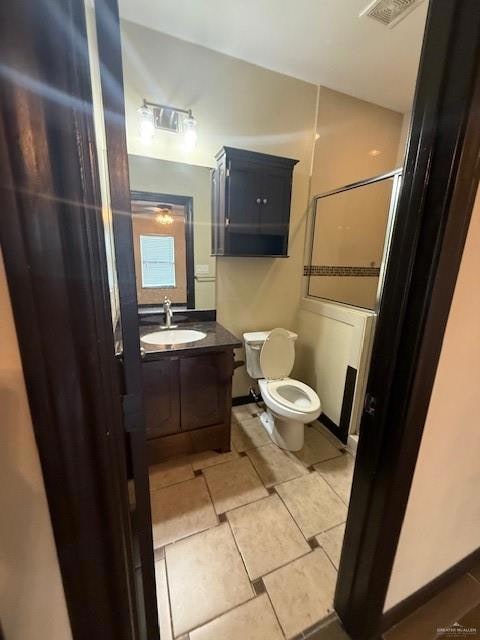 Bathroom with toilet, vanity, and tile patterned flooring