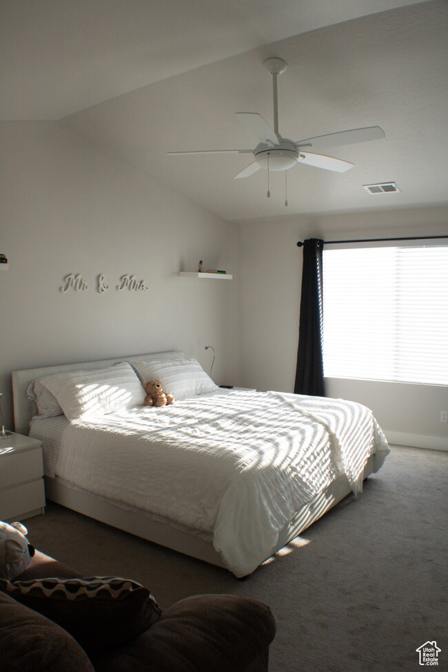Bedroom with carpet floors, lofted ceiling, and ceiling fan