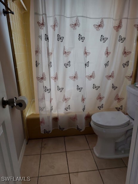 Bathroom featuring toilet, shower / bath combo wit