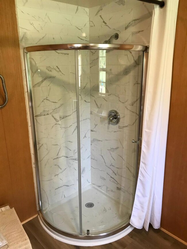 Bathroom featuring a marble finish shower and dar