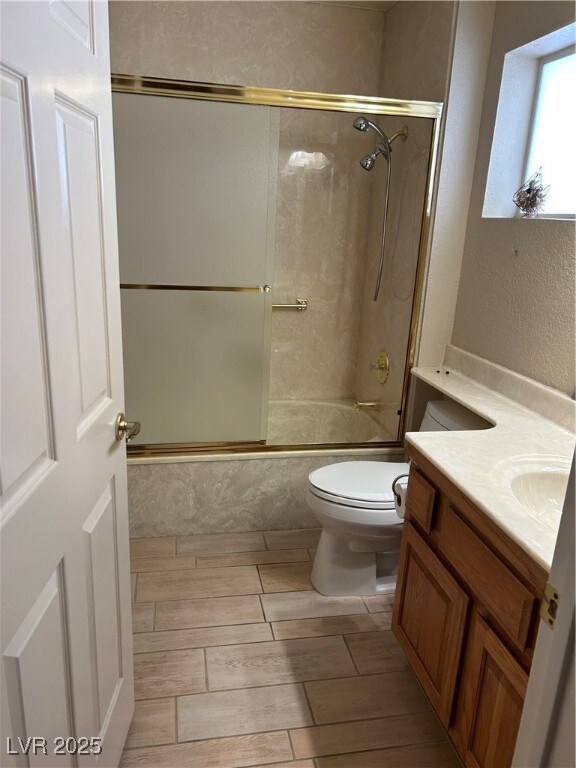 Bathroom with vanity, bath / shower combo with gla