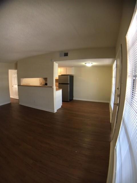 Unfurnished living room with dark wood finished f