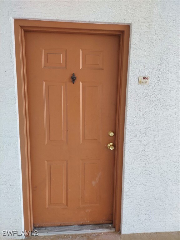 Doorway to property featuring stucco siding