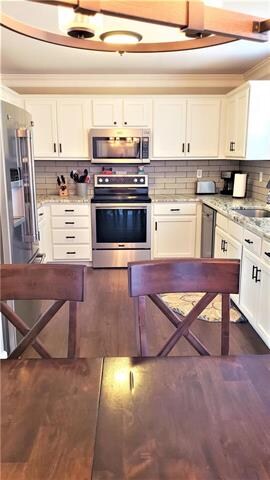 White cabinets and stainless appliances.