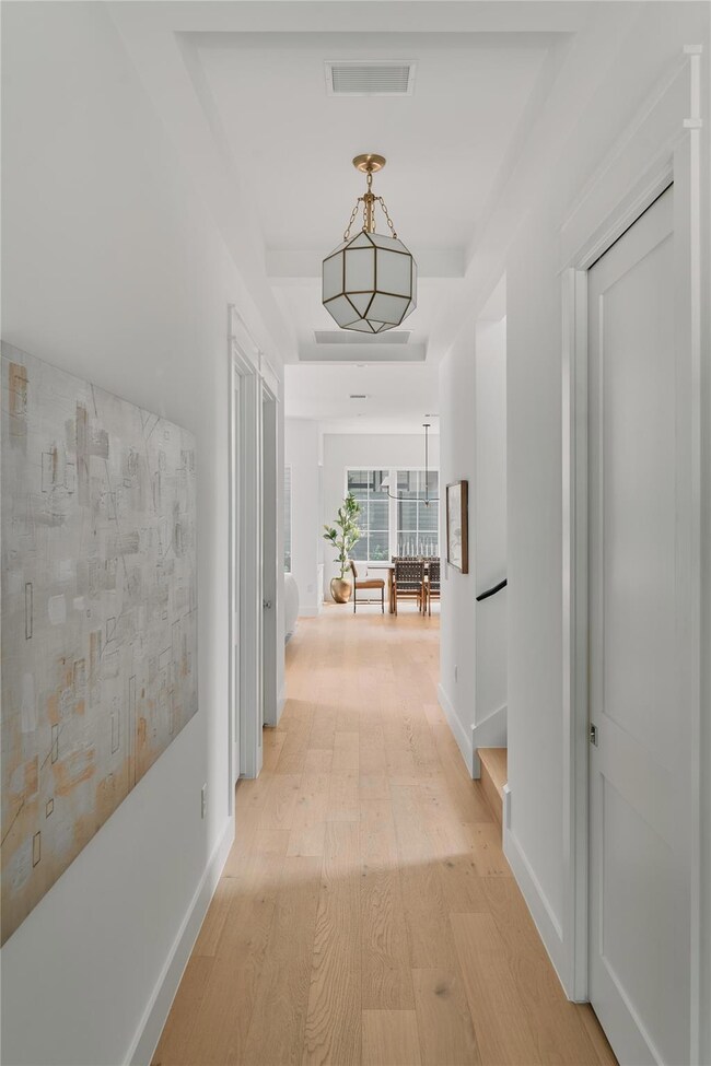 Hall featuring light wood finished floors and bas