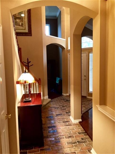Additional view of foyer coming from the den, featuring arched doorways, direct walk to study and formal dining area.