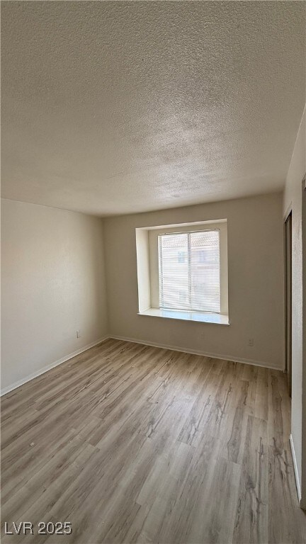 Spare room with wood finished floors and a texture