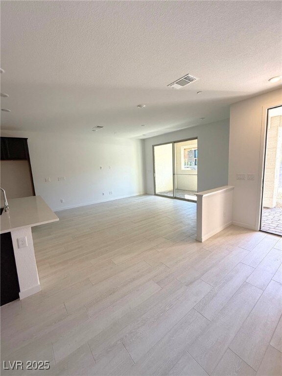 Empty room featuring light wood finished floors, b